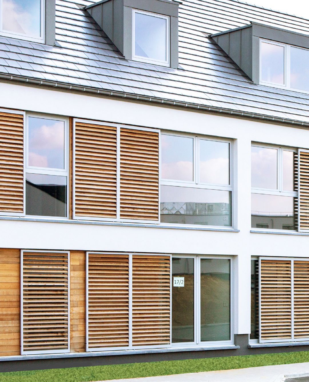 Façade de logements collectifs rythmée par des protections solaires en bois